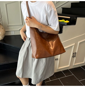 Detail der dunkelbraunen Leder-Shopper-Tasche mit Mittelnaht und breitem Riemen