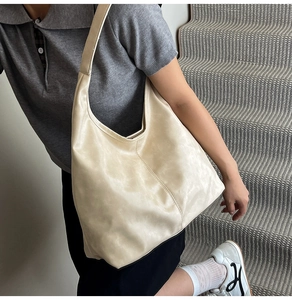 Detail einer großen cremefarbenen Hobo-Tasche mit minimalistischer vertikaler Mittelnaht