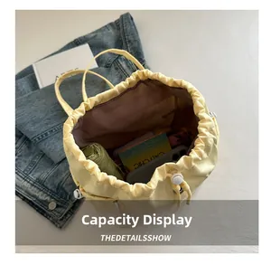 Top view of yellow drawstring bag showing capacity with umbrella, phone and wallet inside