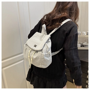 Detail of checkered casual backpack with drawstring flap closure on model back