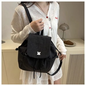Close-up of black plaid drawstring backpack with silver buckle and fine check pattern