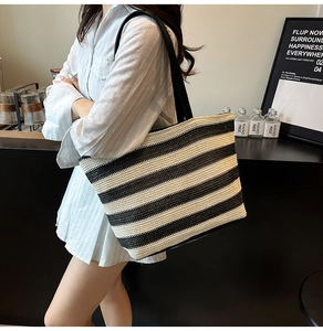 Dettaglio della borsa tote intrecciata a righe bianche e nere con tracolla resistente