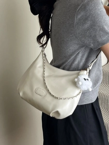 Creamy white faux leather crescent shoulder bag with silver chain and plush charm