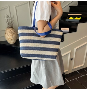 Dettaglio della borsa tote intrecciata a righe blu navy e beige con manici in pelle