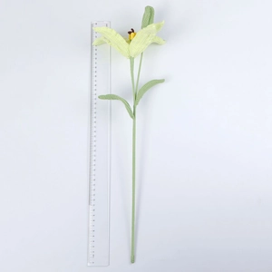 Detail of a 50cm handmade crochet lily flower in pale yellow yarn with green leaves