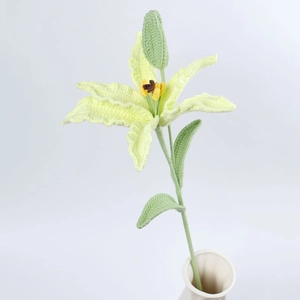 Detail of hand-knitted crochet lily flower with realistic petals and blooming bud