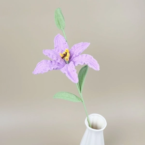 Detail of handcrafted crochet purple lily flower with green bud and leaves for home decor