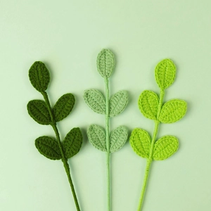 Detail of three handmade knitted leaf stems in various green tones for floral decoration