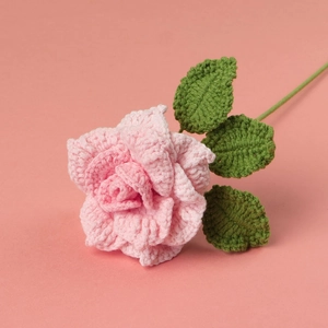 Handgefertigte rosa Häkelrose mit grünen Blättern für DIY-Blumen-Hausdekoration