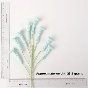 Vue détaillée d'un bouquet de fleurs crochetées vert menthe avec règle pour la taille