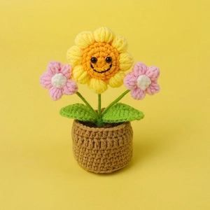 Handmade crochet sunflower potted plant with cute smiley face and yellow backdrop