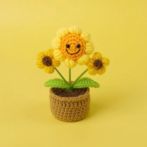 Close-up of hand-knitted sunflower potted plant with cute smiling face for desk decor