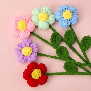 Macro shot of five colorful hand-knitted chenille flowers in a fan-shaped arrangement