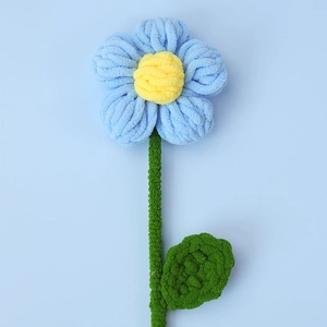 Macro shot of handmade crochet puff flower bouquet in light blue chenille yarn