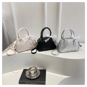 Detailed view of mini Boston bags in beige, black and silver with floral embossing