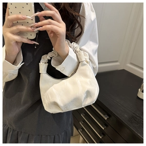 Detailed view of the soft ruffled cream handbag with a scrunchie-style top handle