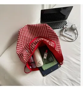 Interior view of red plaid canvas tote bag showing large capacity for laptop and daily items