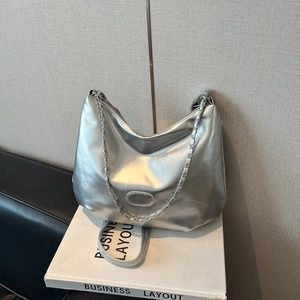 Détail d'un sac hobo argenté métallisé avec bandoulière chaîne et surpiqûres ovales élégantes