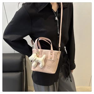 Rosa Handtasche mit Schmetterlingsprägung und weißem Hundeanhänger getragen von Model