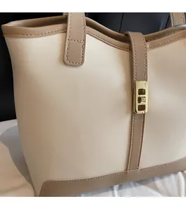 Detail of elegant two-tone tote bag with gold metal buckle and textured faux leather