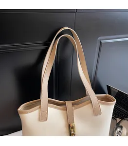 Detail of crossbody bag featuring dual shoulder straps and a golden rectangular clasp