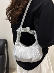 Silver metallic pleated cloud crossbody bag with ruffled handle shown on model