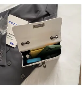 Vue intérieure du sac bandoulière blanc à fraises avec chaîne et accessoires du quotidien