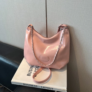 Vue détaillée d'un sac hobo rose en cuir verni avec chaîne argentée et finition brillante