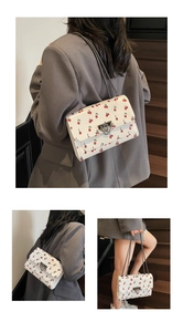 Trois vues d'un sac bandoulière blanc avec imprimés cerises et chaîne argent