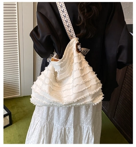 Détail du sac Hobo en toile blanche avec franges et bandoulière ethnique