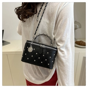 Detail of black quilted leather box bag with sparkling crystals and silver chain strap