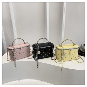 Detailed shot of quilted mini vanity bags with metal studs and camellia floral charms