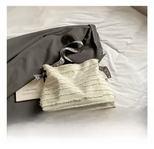 Détails du sac fourre-tout blanc avec bords effilochés et bandoulière zébrée