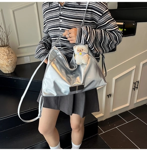 Silver metallic tote bag with adjustable strap and ruffled texture shown on model