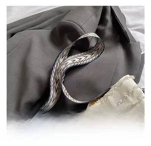 Détail de la bandoulière géométrique tissée noire et blanche avec sac en toile à franges
