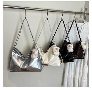 Close-up of retro biker tote bags in silver, cream, black and brown with bear charms