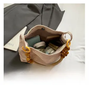 Détail du sac brodé rose montrant sa grande capacité et ses poignées en perles de bois