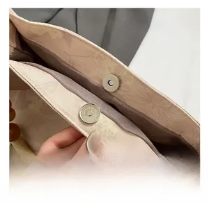 Détail de la boucle magnétique argentée sur sac seau brodé chinois avec perles en bois