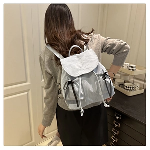 Détail du sac à dos bleu clair en nylon avec broderie NIKA et un nœud décoratif noir