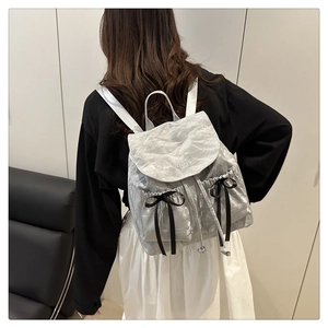 Detail of silver crinkled backpack with black silk bows and Nika embroidery