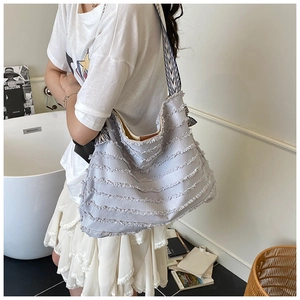 Detail der lila Canvas-Tasche mit gestuften Volants und gestreiftem Schultergurt-Design