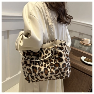 Detail showing the leopard print plush tote texture and leather strap with metal ring