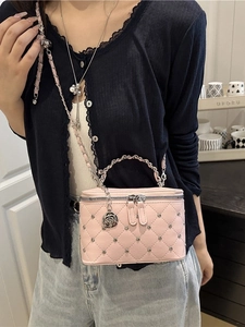Pink quilted bucket bag with silver studs and camellia charm shown on a fashion model
