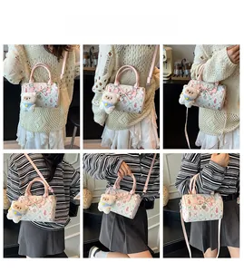 Detail view of mini Boston bag featuring floral heart prints and cute bear charm accessory