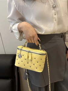 Elegant yellow quilted bucket bag with chain strap and camellia pendant for women