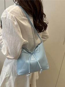 Elegante hellblaue Schultertasche mit Schleifen-Detail und silbernen Metallperlen