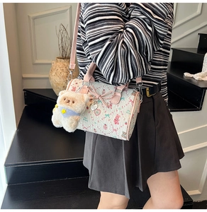 Detail shot of the Boston cylinder bag with cute bunny print and plush bear charm