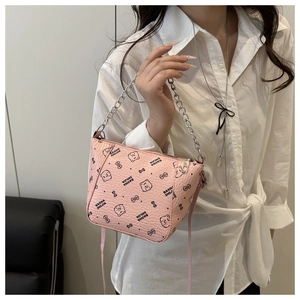 Detail of pink bucket bag with bear patterns and silver chain strap held by model
