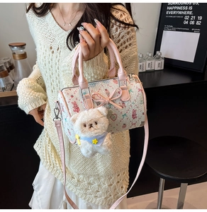Detail of cream Boston bag with floral bear prints and cute plush charm in a lifestyle set