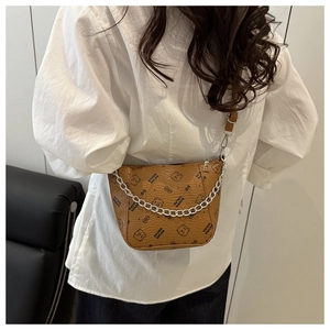 Detailed view of brown bucket bag with teddy bear print and silver chain link strap